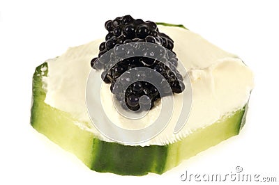 Amuse bouche with a slice of cucumber, cream cheese and black lump eggs close-up on a white background Stock Photo