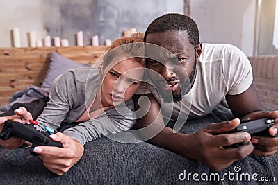 Amused couple playing video games in bedroom together Stock Photo