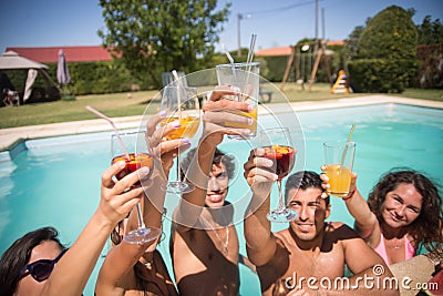 Amused friends resting at poolside in summer Stock Photo