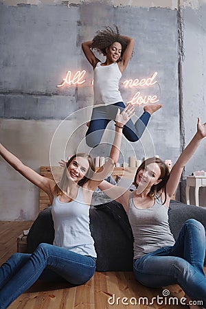 Amused girl jumping and having fun with friends Stock Photo