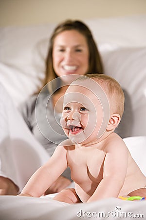 Amused six month old baby with mom in background Stock Photo