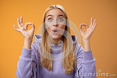 Amused talented creative young blond female tell excellent idea show okay no problem gesture persuade friends everything Stock Photo
