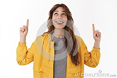 Amused wondered cute young 25s girlfriend look up smiling cheerful pointing upwards mesmerized fascinated awesome copy Stock Photo