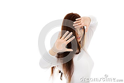 Amused young woman hides behind her hands Stock Photo