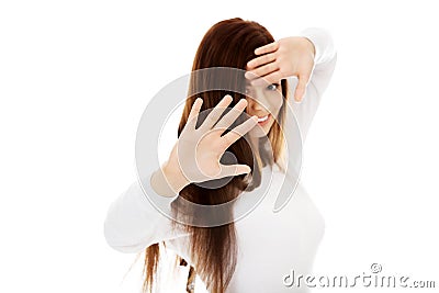 Amused young woman hides behind her hands Stock Photo