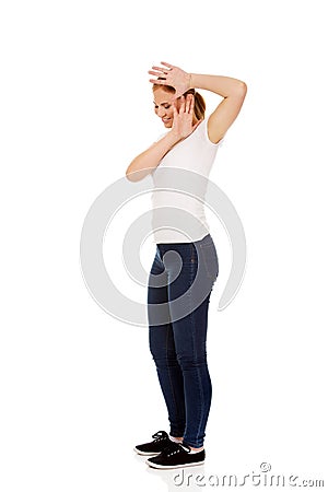Amused young woman hides behind her hands Stock Photo