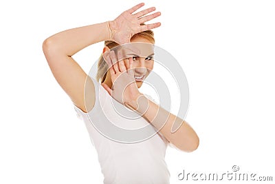 Amused young woman hides behind her hands Stock Photo