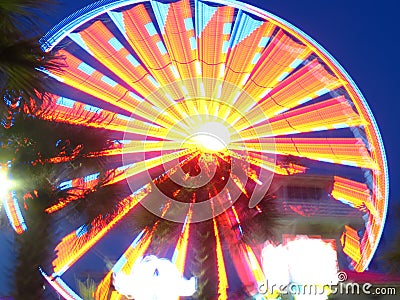 Amusement park Ferris wheel with blurred multicolored lights Stock Photo