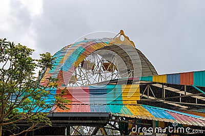 Amusement park old giant wheel colorful tin roof during heavy rain Stock Photo