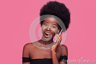 Amusing African American woman chatting with girlfriends on phone or smartphone. Female model with afro hairstyle Stock Photo
