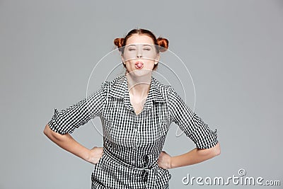 Amusing cute young woman showing tongue and making funny face Stock Photo