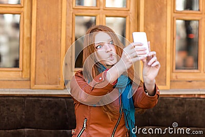 Amusing girl making funny faces and taking photos of herself Stock Photo