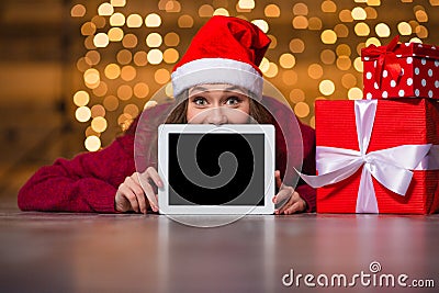 Amusing positive girl lying and hiding behind tablet blank screen Stock Photo