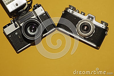 Analog cameras on yellow background. copy space Stock Photo