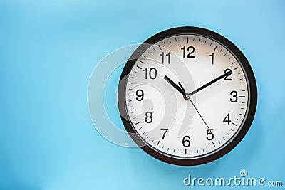 Analog classic black and white clock on Blue background Stock Photo