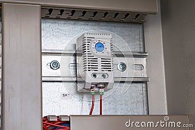 The analog thermostat is mounted in an electrical Cabinet Stock Photo