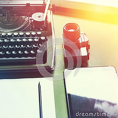 Analog Typewriter, Digital Tablet And Film Camera On The Green Table, Top View with Sunshine. Journalism Writing Concept Stock Photo