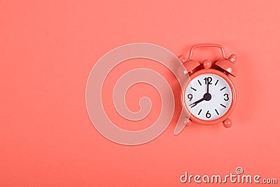 Alarm clock on coral background Stock Photo