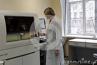Analyst load the blood samples into automated analysis system Editorial Stock Photo