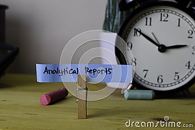 Analytical Reports. Handwriting on sticky notes in clothes pegs on wooden office desk Stock Photo