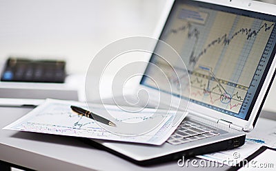 Analyzing investment charts with laptop. Stock Photo