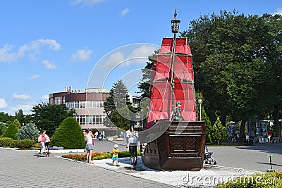 Anapa, Russia, July, 18, 2018. People walking on the promenade next to the sailboat `Scarlet sails` on Anapa resort in sunny day Editorial Stock Photo