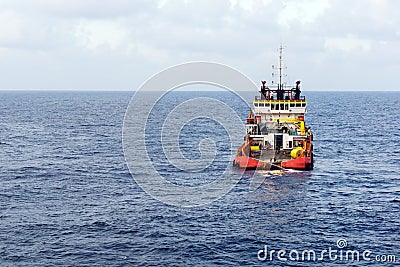 An anchor handling tug boat maneuvering at offshore oil field Stock Photo