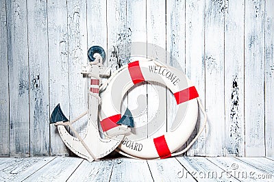 Anchor and life buoy on a background of white wall. Stock Photo