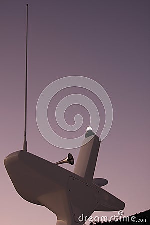 Anchor light, horn and radio antenna atop the mast of a catamaran Stock Photo