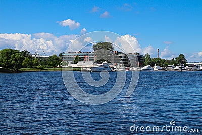 Anchorage of yachts on the river against the background of houses and a blue sky with clouds. St. Petersburg Editorial Stock Photo