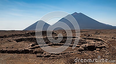 ancient archeology of stone houses with a volcano in the background in high resolution and sharpness in Latin America Stock Photo