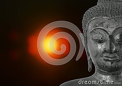ancient Buddha image on blurry candle light in dark Stock Photo