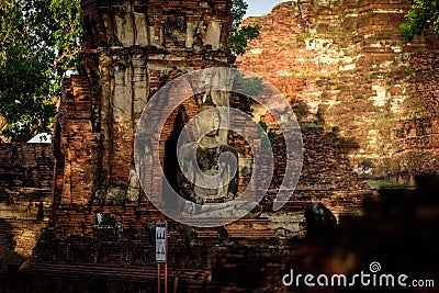 Ancient Buddha Statue broken in the morning with sunrise at Mahathat Temple, Ayutthaya, Thailand. Stock Photo