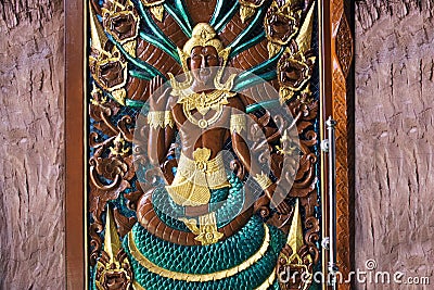 Ancient carving deity naka and naga angel frescoes painting on wooden door of antique building ubosot for thai people traveler Stock Photo