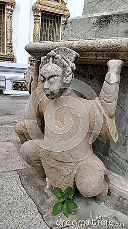 Ancient Chinese soldier stone sculpture carry the pagoda at Wat Po Stock Photo