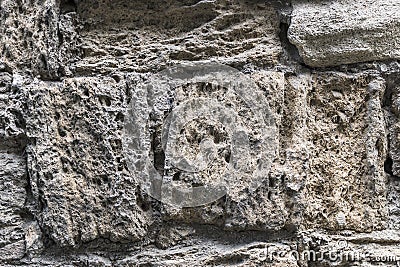 Ancient crumbling stones are located in the old fortress wall. Stock Photo