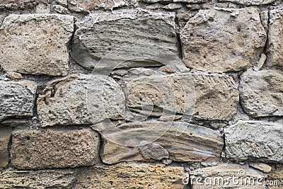 Ancient crumbling stones are located in the old fortress wall. Stock Photo