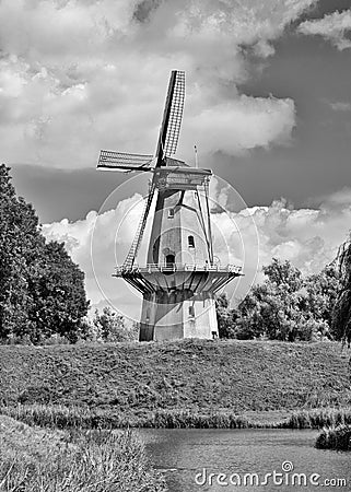 Ancient floor mill build on a city wall with dramatic clouds, Netherlands Stock Photo