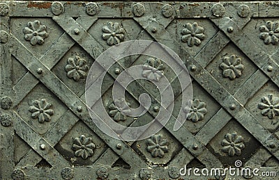 Ancient forged metal texture with decorative overlays. Doors, gates, shutters. Detail of a medieval gray door with metal decoratio Stock Photo