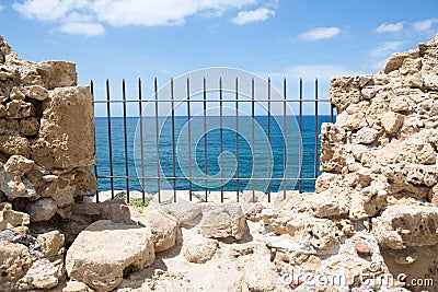 Ancient fortress wall with sea view through the grill Stock Photo