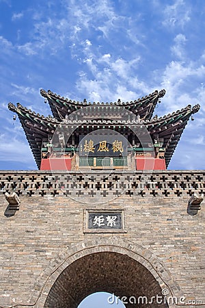 Ancient gate with pagoda againts a blue sky with dramatic clouds, Pingyao, China Editorial Stock Photo