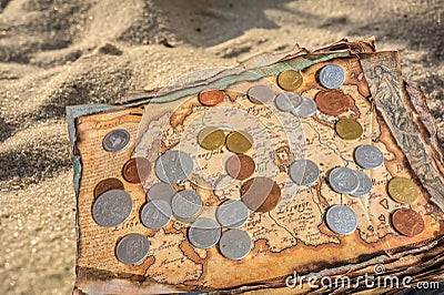 Ancient geographic map with coins lies on the seashore Stock Photo