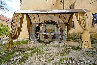 an ancient gilded carriage in the courtyard of the castle Stock Photo