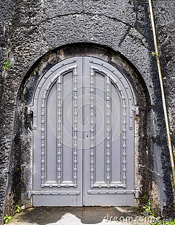 Ancient grey castle arched door with studded pattern Stock Photo