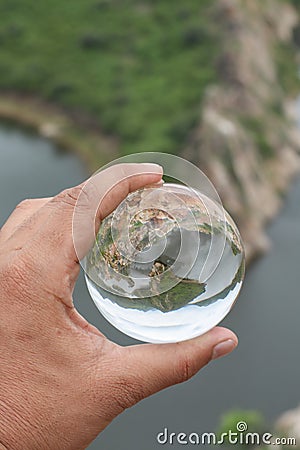 A man holding lensball in his hand with a reflection Stock Photo