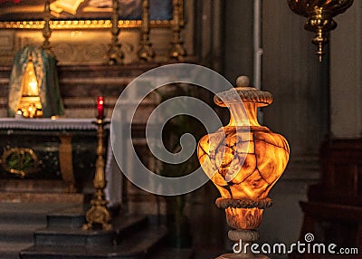 Ancient illuminated alabaster vase shows the face of Medusa and numerous cracks Stock Photo