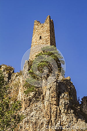 An ancient impregnable stone castle built on the pinnacles of steep rocky cliffs. Stock Photo