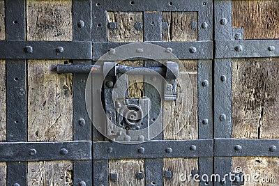 Ancient iron lock with latch on aged boarded door. Stock Photo