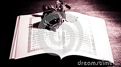 An ancient Koran and a red red symbol of love Stock Photo