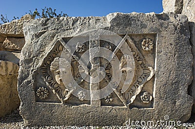 Ancient Lycian stone slab with portraits of people carved in stone in geometric form with floral decoration Stock Photo